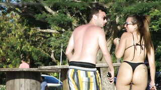 Vrouw met een geweldige dikke kont die string draagt wordt gefilmd op het strand