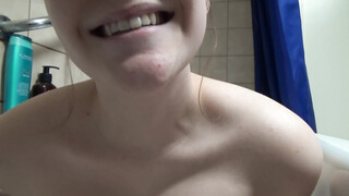Ze is aan het masturberen in bad met douchemuts