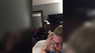 Sexy jonge vrouw met witte kousen en een bril die aan een lul zuigt