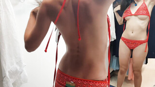 Brunette vrouw met harig poesje probeert zwempak in een paskamer